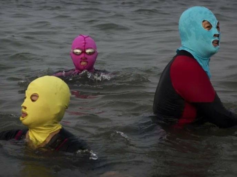 شاهد: صينيون يرتدون أقنعة ملونة أثناء السباحة والكشف عن السبب