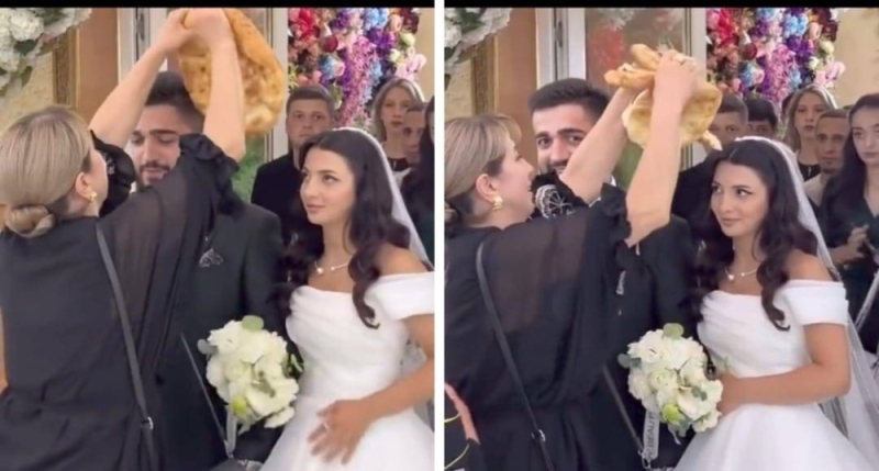 شاهد.. امرأة تقطع الخبز فوق رأس عروسين في حفل زفافهما  وتثير الجدل