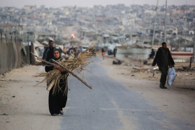 فلسطينية تحمل حَطباً لاستخدامه بالطهو في خان يونس (أ ف ب)