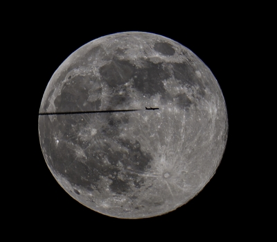 طائرة تشق طريقها أمام القمر الأكبر في سماء البلاد (تصوير أسعد عبدالله)