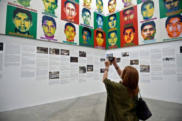 A woman taks a picture of Chinese contemporary artist and activist Ai Weiwei's new exhibition at the University Museum of Contemporary Art (MUAC) in Mexico City on April 11, 2019. - Ai Weiwei unveiled the portraits of the 43 Mexican missing students of Ayotzinapa made with one million Lego pieces. (Photo by ALFREDO ESTRELLA / AFP)