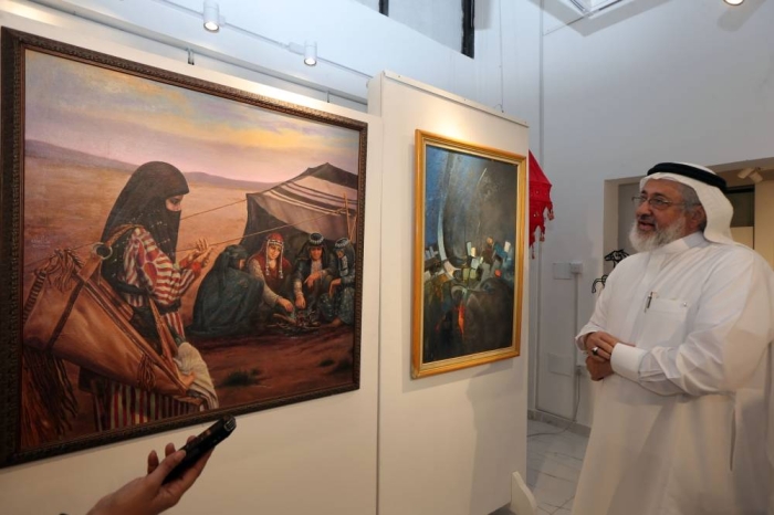 هشام بنجابي الفنان التشكيلي أمام أحد لوحاته (تصوير:علي حميدة)