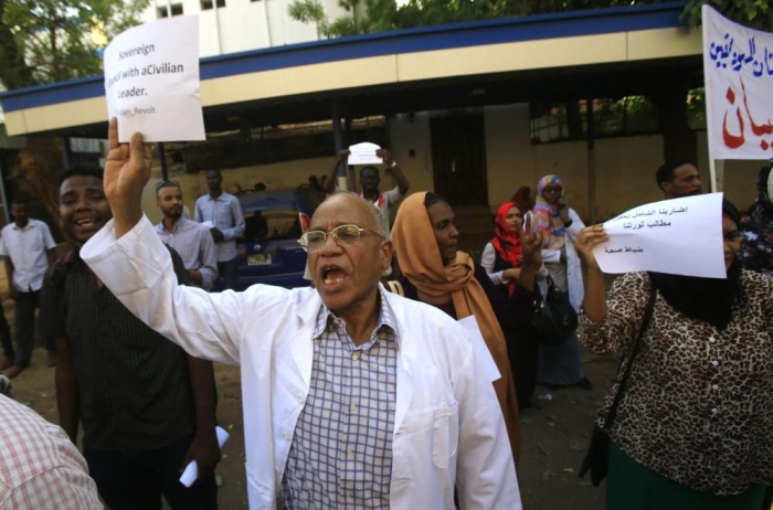 A Sudanese health worker carries a placard as scores of medics hold a rally in front of a hospital in the capital Khartoum on May 23, 2019. - Sudan's protest leaders said today they will seek advice from demonstrators camped outside the army headquarters on how to break a deadlock in talks with the military on installing civilian rule.
Medics along with engineers and teachers played a key role in nationwide protests against Omar al-Bashir's rule by forming the Sudanese Professionals Association, the group that initially launched the anti-Bashir campaign. (Photo by ASHRAF SHAZLY / AFP)