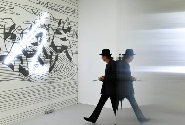 15 August 2019, Berlin: A man walks by artworks of the artist Flaka Haliti in the exhibition of the 