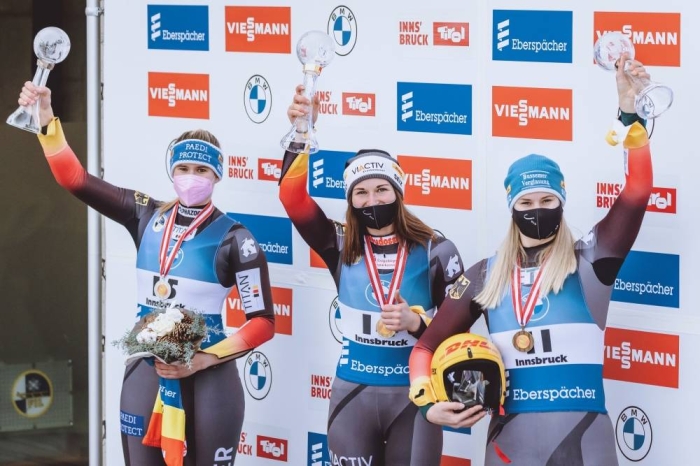 (LtoR) Second placed Germany's Natalie Geisenberger, overall World Cup winner Germany's Julia Taubitz and third placed Germany's Dajana Eitberger celebrate during the awarding ceremony for the women sprint competition of Luge World Cup at the Olympia Eiskanal in Innsbruck, Austria, on January 24, 2021. (Photo by JFK / various sources / AFP) / Austria OUT