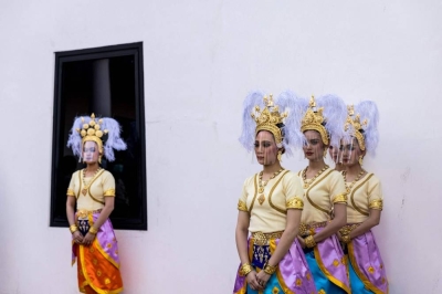 A traditional Thai dancers wears a plastic face shield during an event to mark the return of two ancient sandstone lintels, sacred late 10th or 11th century sandstone support beams, at the Bangkok National Museum in Bangkok on May 31, 2021. (Photo by Jack TAYLOR / AFP)