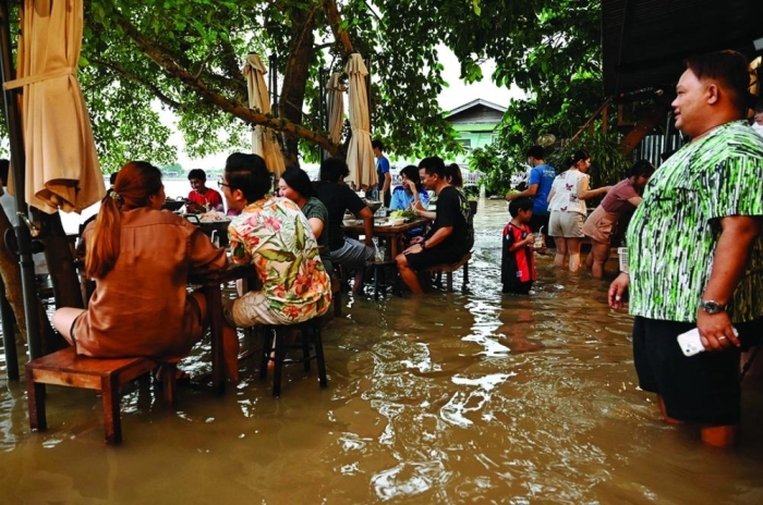 رواد مطعم يحجزون في مطعم تايلاندي لتناول الطعام بين مياه الفيضان
