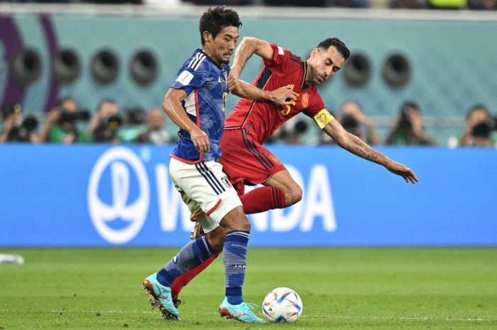 Japan's midfielder #13 Hidemasa Morita (L) fights for the ball with Spain's midfielder #05 Sergio Busquets during the Qatar 2022 World Cup Group E football match between Japan and Spain at the Khalifa International Stadium in Doha on December 1, 2022. (Photo by Philip FONG / AFP)