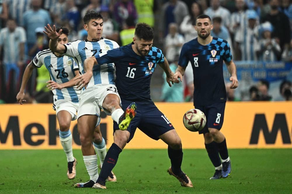 Argentina&amp;#039;s forward #21 Paulo Dybala and Croatia&amp;#039;s forward #16 Bruno Petkovic fight for the ball during the Qatar 2022 World Cup football semi-final match between Argentina and Croatia at Lusail Stadium in Lusail, north of Doha on December 13, 2022. (Photo by Jewel SAMAD / AFP)