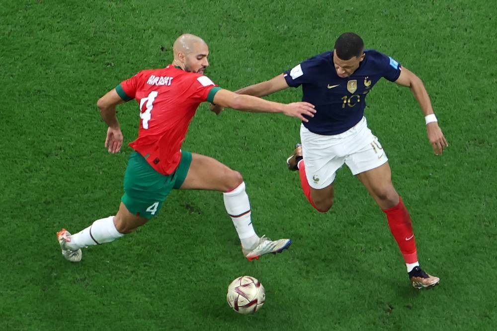 Morocco's midfielder #04 Sofyan Amrabat (L) and France's forward #10 Kylian Mbappe fight for the ball during the Qatar 2022 World Cup semi-final football match between France and Morocco at the Al-Bayt Stadium in Al Khor, north of Doha on December 14, 2022. (Photo by Giuseppe CACACE / AFP)