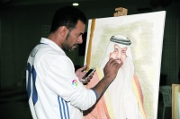 فنان يقوم برسم صورة الأمير سعود بن نايف في المعرض (تصوير: إبراهيم السقوفي)