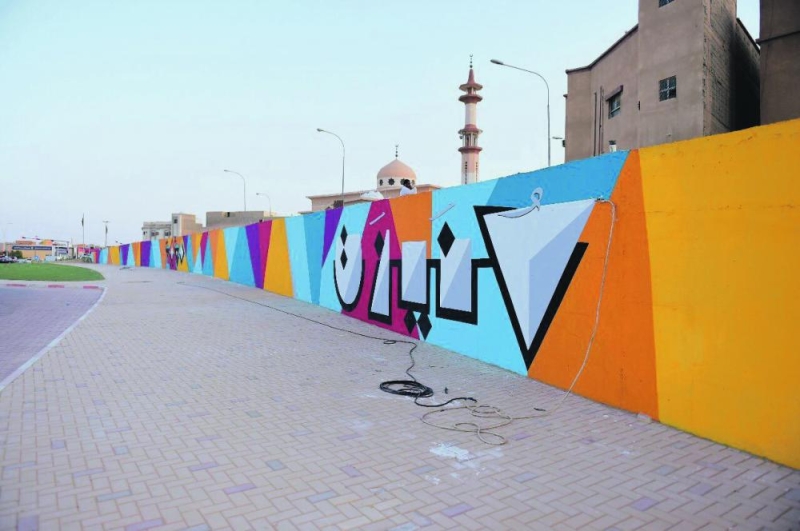 فنانات يرسمن جدارية 2030 بعنيزة