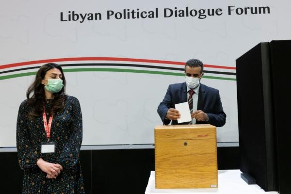 مندوب يدلي بصوته لانتخاب حكومة مؤقتة جديدة لليبيا خلال منتدى جنيف (رويترز)