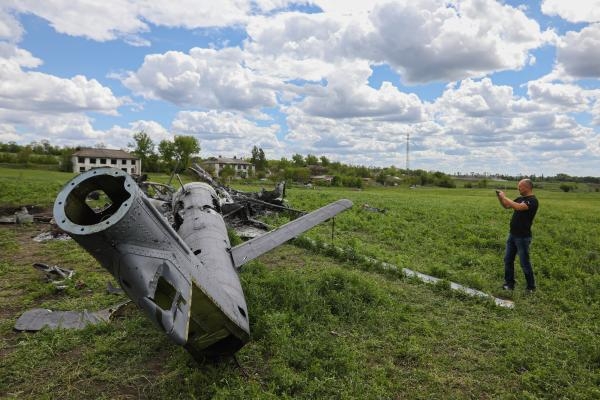 رجل يلتقط صورة لطائرة روسية أسقطت أمس في بيسكفيتني شرق خاركيف (د ب أ)