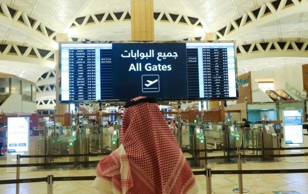 مواطن سعودي يتفقد مواعيد الرحلات في مطار الملك خالد الدولي بالرياض - رويترز