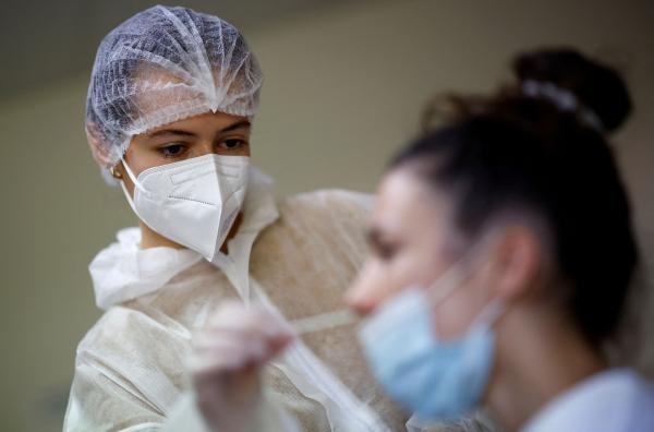 عاملة بالقطاع الطبي تأخذ مسحة أنفية لمريضة في مركز اختبار مرض فيروس كورونا - رويترز