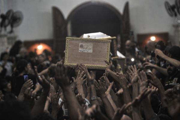 أشخاص يحملون نعش أحد الضحايا الذين لقوا حتفهم في حريق كنيسة أبو سيفين- رويترز