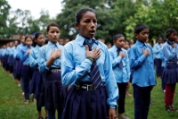 الأم تغني النشيد الوطني لنيبال أثناء حضورها تجمعًا في المدرسة- رويترز