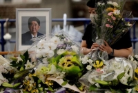 أحد المعزين بجانب صورة رئيس الوزراء الياباني الأسبق الراحل شينزو آبي بعد أسبوع من اغتياله- رويترز