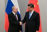 الرئيس الصيني شي جين بينغ يصافح نظيره الروسي فلاديمير بوتين (رويترز)