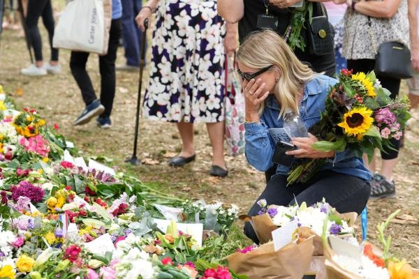 البريطانيون يضعون الورود حول القصور ومختلف المناطق الخاصة بالملكة إليزابيث عقب وفاتها- رويترز