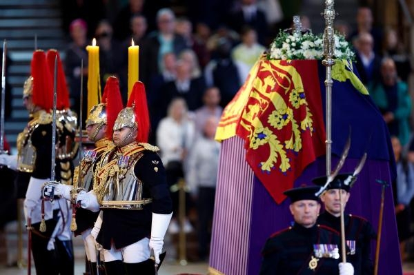 يقف أفراد من سلاح الفرسان والعائلة المالكة في مكان حراسة حيث يرقد تابوت الملكة إليزابيث الثانية- رويترز