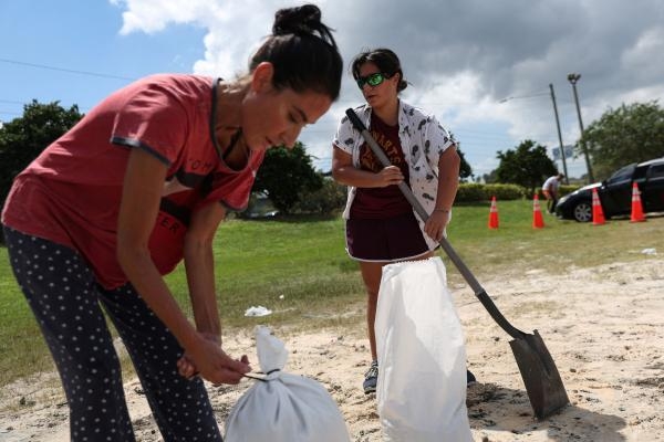 كاثرين كوروفيسي وابنتها ميلينا يملآن أكياس الرمل بينما الإعصار إيان يتجه نحو فلوريدا- رويترز