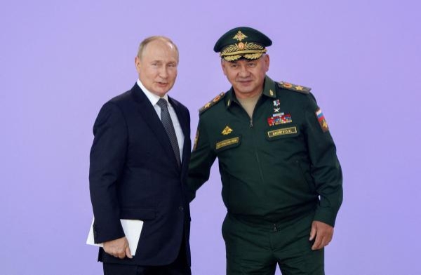 الرئيس الروسي ووزير دفاعه خلال احتفال للجيش في العاصمة موسكو (رويترز)