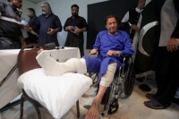 عمران خان يجلس على كرسي متحرك عقب تعرضه لإطلاق نار (رويترز)
