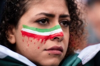 مشاركة في مسيرة بمدينة كولونيا الألمانية تتضامن مع الإيرانيين ترسم العلم على وجهها - د ب أ