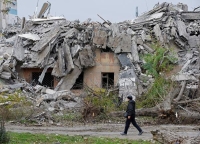 مواطن أوكراني يسير بجوار منزل دمره هجوم صاروخي روسي - رويترز 