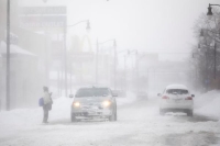 شخص يحاول عبور الشارع خلال عاصفة ثلجية ضربت منطقة بوفالو بنيويورك- رويترز 
