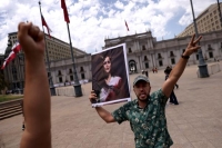 إيراني في تشيلي يحمل صورة مهسا أميني خلال مظاهرة بالعاصمة سانتياغو - رويترز