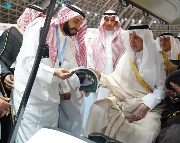 الأمير خالد الفيصل يطلع على أحد إصدارات جناح سيرة الملك عبد الله بن عبد العزيز المشارك في معرض جدة للكتاب - واس