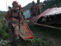 عمال الإنقاذ في أثناء عملية الإنقاذ والإجلاء بعد الانهيار الأرضي في باتانج كالي (ماليزيا) - رويترز 