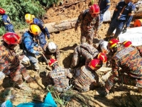 عمال الإنقاذ يقومون بإجلاء ضحايا الانهيار الأرضي - رويترز