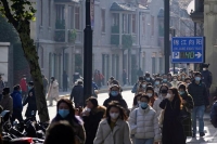 صينيون يرتدون أقنعة الوجه مع استمرار تفشي فيروس كورونا في شنغهاي- رويترز