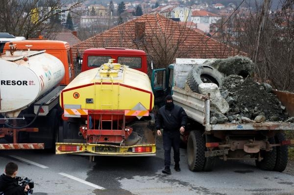 رجل صربي يستعد لإزالة الحواجز وضعت على الطريق في روداري - رويترز
