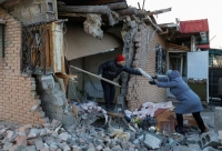 سكان محليون يزيلون الأنقاض الناجمة عن القصف على منطقة دونيتسك - رويترز