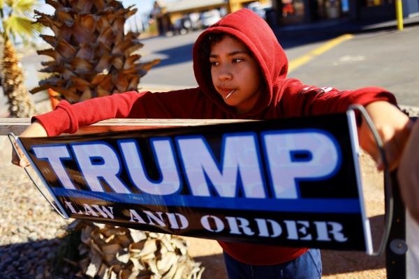 طفل أمريكي يحمل لافتة تأييد لترشح ترامب في الانتخابات الرئاسية - رويترز