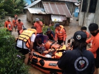أعضاء من خفر السواحل الفلبيني يساعدون السكان المتضررين من الفيضانات خلال عملية إنقاذ في مدينة لاميتان، الفلبين- رويترز