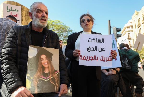 عائلة ضحية بانفجار بيروت ترفع صورة ابنتها أثناء انعقاد جلسة البرلمان - رويترز