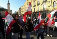 لبنانيون يحملون أعلام بلادهم أمام مبنى مجلس النواب - رويترز