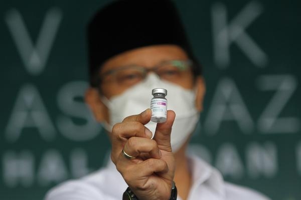 وزير الصحة الإندونيسي بودي جونادي صادقين يمسك بلقاح أسترا زينيكا - رويترز