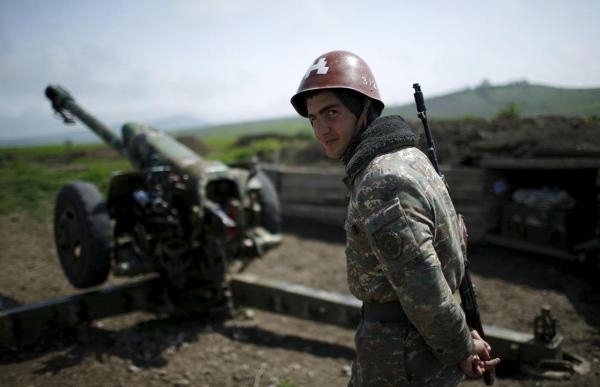 جندي من أصل أرمني يقف بجانب مدفع في ناغورنو كاراباخ- رويترز