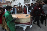 رجال ينقلون جثة بعد تفجير انتحاري في مسجد بمبنى مستشفى في بيشاور، باكستان - رويترز