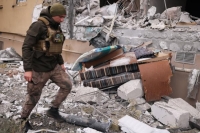 جنود أوكرانيون يزيلون صاروخ جراد في منزل مدمر بعد هجوم روسي - رويترز