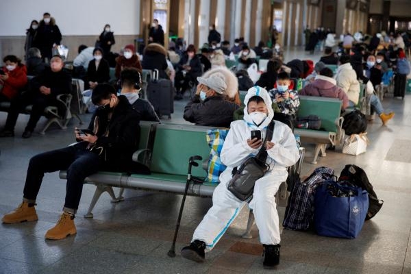 مسافر صيني يرتدي كمامة بعد رفع قيود كورونا في الصين - رويترز