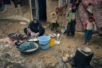 أفغانية تغسل الملابس أمام منزلها بمخيم نازحين في ضواحي كابول- واشنطن بوست