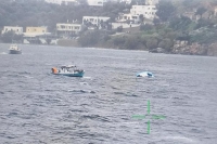 قارب صيد يقترب من قارب قابل للنفخ نصف غارق كان يحمل مهاجرين قبالة جزيرة ليروس - رويترز